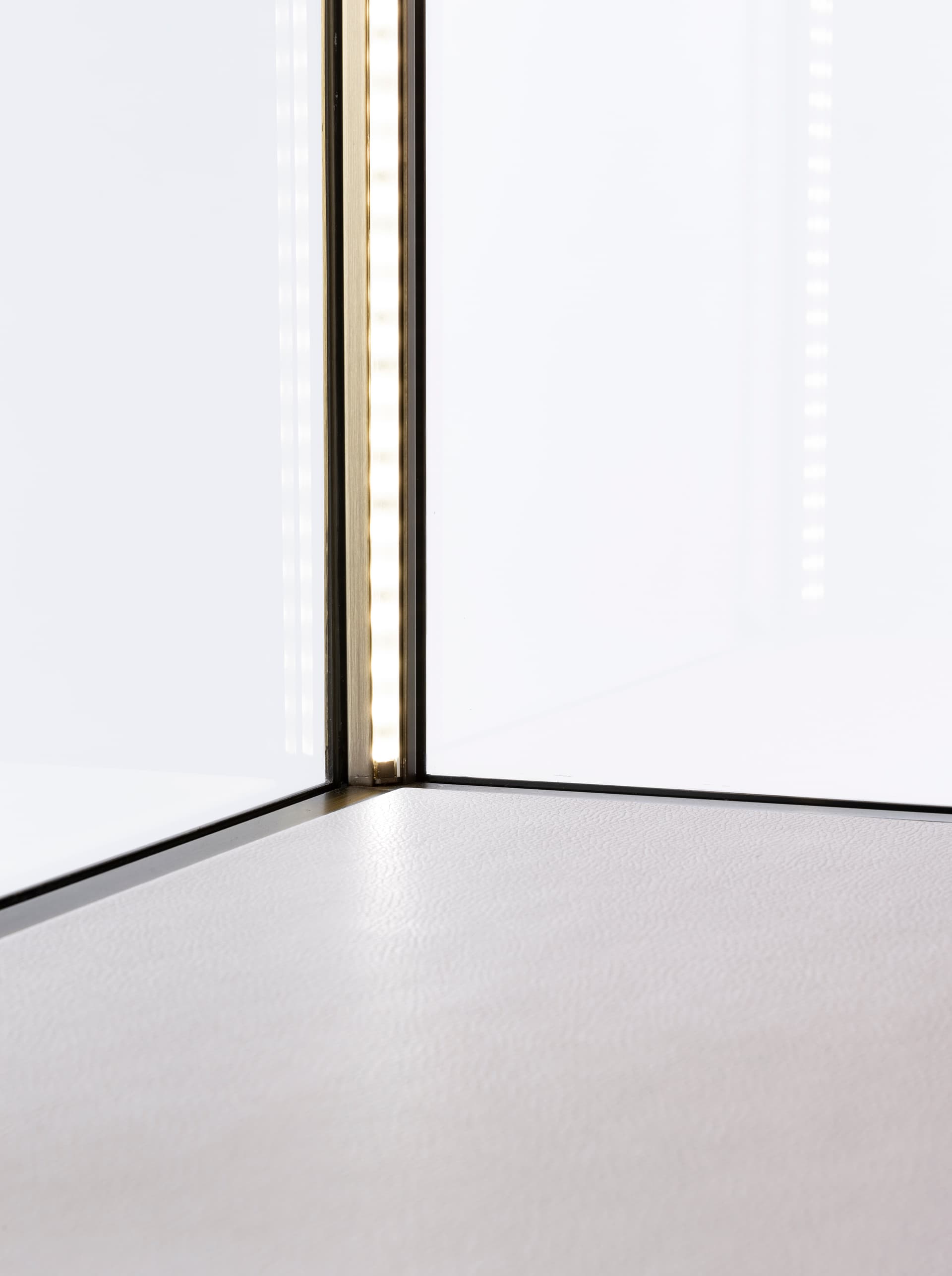 Square glass curio box with LED corner lighting and white leatherette floor