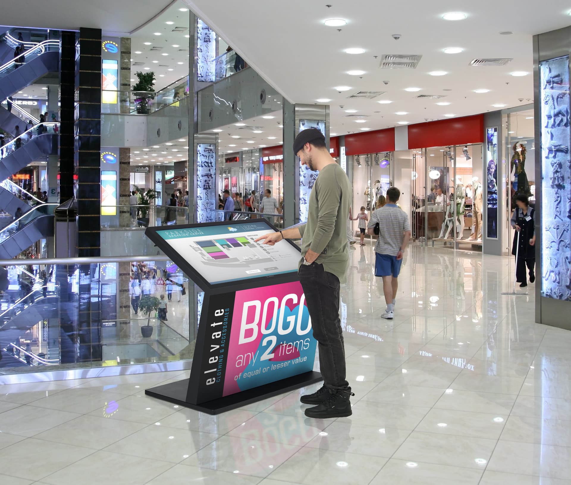 Touch screen interactive kiosk being utilized in a shopping mall setting