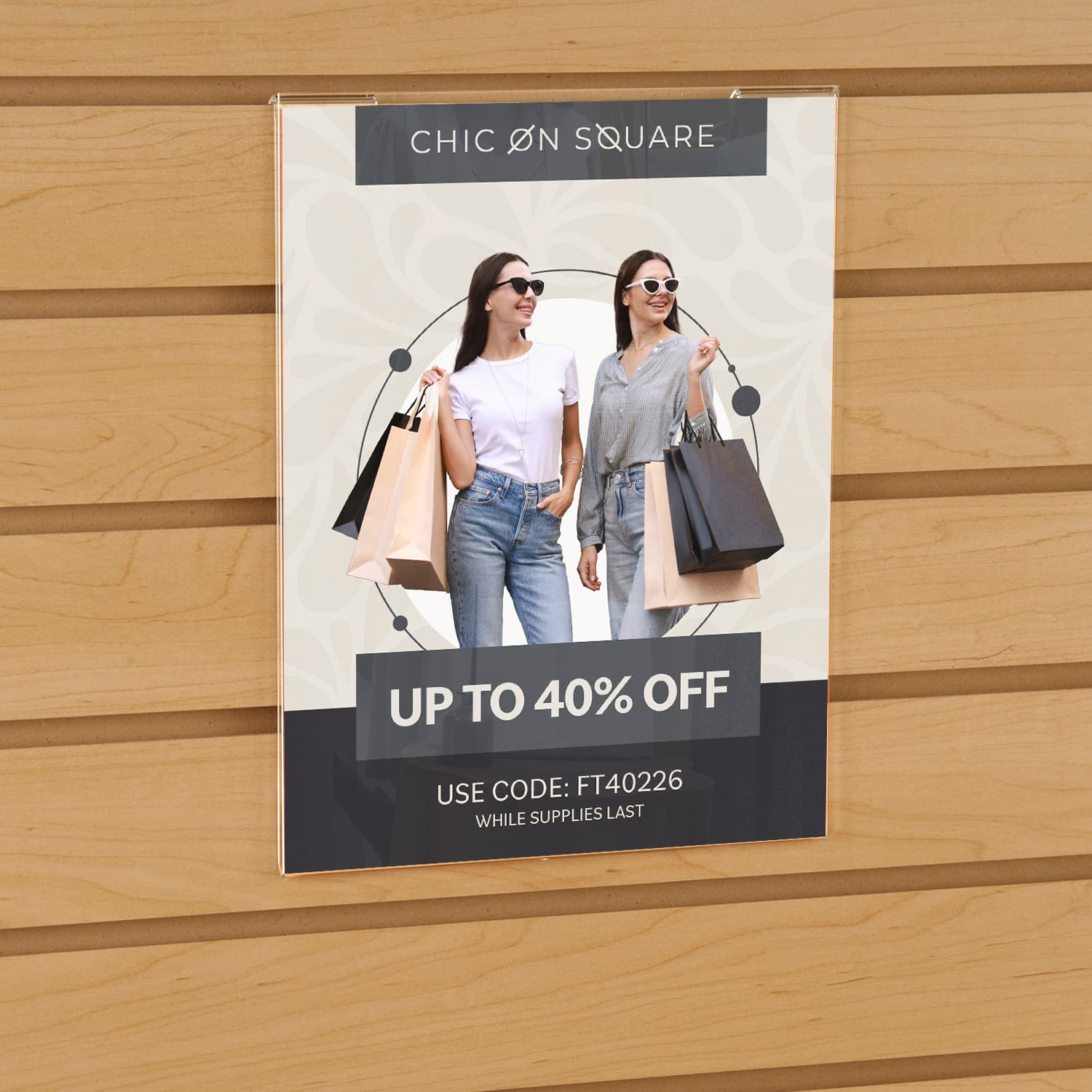 Acrylic gridwall sign holder being shown on a slatwall advertising a clothing sale