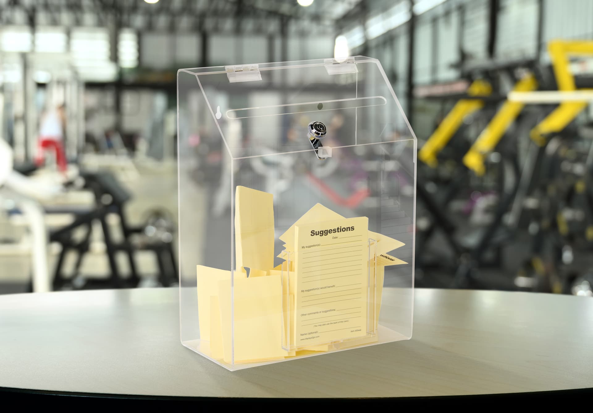 Clear acrylic suggestion box utilized on a countertop in a gym setting