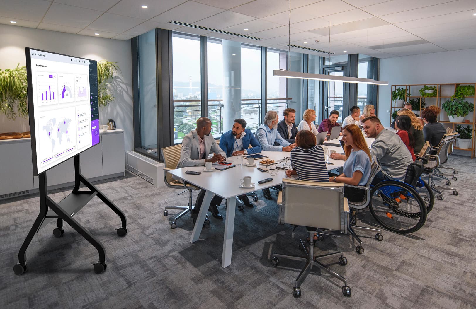 Rolling flat panel TV cart being used in a boardroom setting