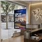 Glass mount sign holder attached to a glass wall of a tourism bureau