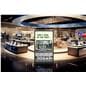 Digital display advertising floor stand exhibiting a graphic promoting upgrading your old TV in a tech store showroom  